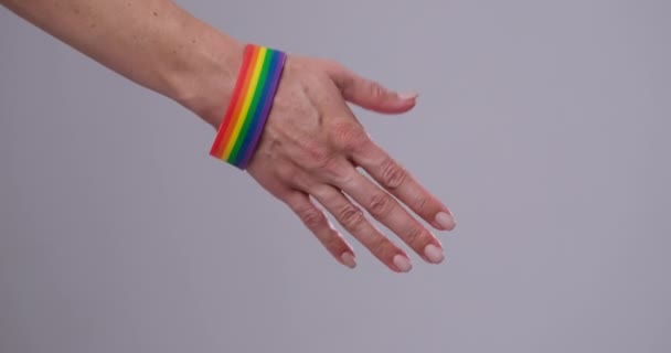 Gay couple holding hands wearing lgbt flag wristbands — Stock Video