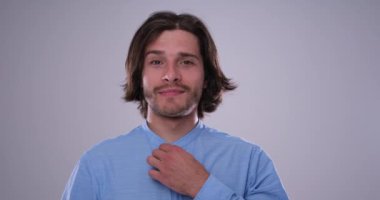 Adam gömleğini beyaz arka planda ayarlıyor.