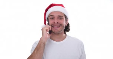 Noel Baba şapkalı adam cep telefonuyla konuşurken eğleniyor.