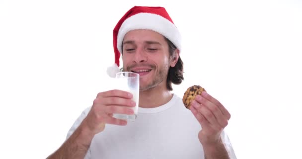 Noel Baba şapkalı adam kurabiye yiyor ve süt içiyor. — Stok video