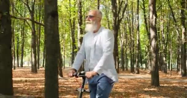 Homem de negócios idoso montando scooter elétrico — Vídeo de Stock
