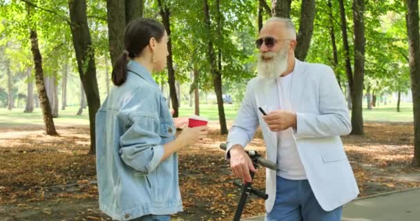 Senior man in gesprek met vrouw in park — Stockvideo