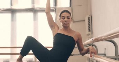 Dans salonunda bacak ve kolla prova yapan balerin.