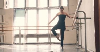 Balerin dans salonunda tırabzan tutup prova yapıyor.