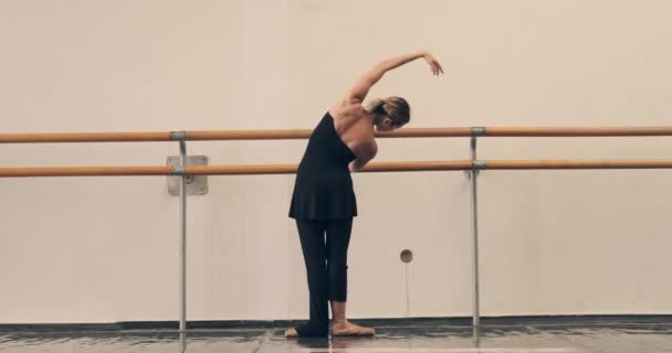 バレリーナはダンスホールで手すりを伸ばし練習 — ストック動画