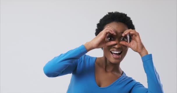 Vrouw op zoek met de hand gemaakte verrekijker — Stockvideo