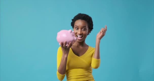 Mujer feliz insertando moneda en alcancía — Vídeos de Stock