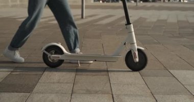 Şehirde elektrikli scooter kullanan bir kadın.