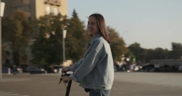 Vrouw met elektrische scooter in de stad — Stockvideo
