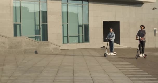 Şehirde elektrikli scooter kullanan bir çift. — Stok video