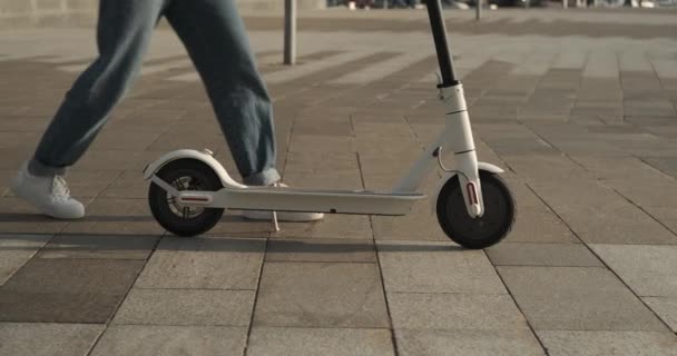 Mujer usando scooter eléctrico en la ciudad — Vídeo de stock