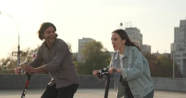 Şehirde elektrikli scooter kullanan kaygısız bir çift. — Stok video