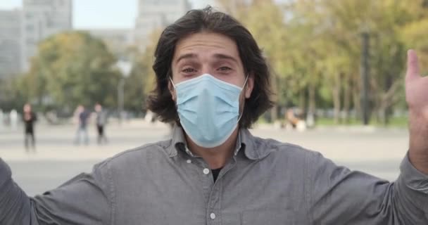 Hombre con mascarilla protectora y saludo saludando con la mano — Vídeos de Stock