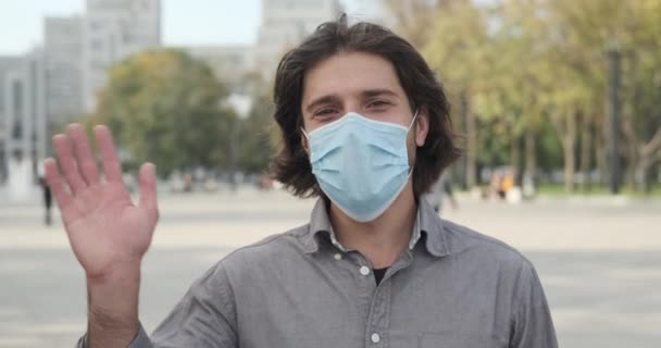 Hombre con mascarilla protectora y saludo saludando con la mano — Vídeos de Stock