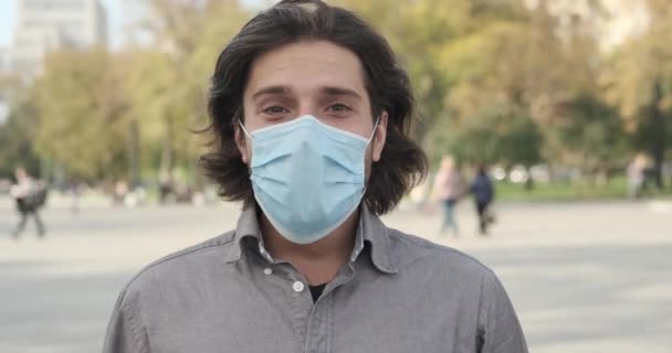 Man wearing protective face mask outdoors in city — Stock Video