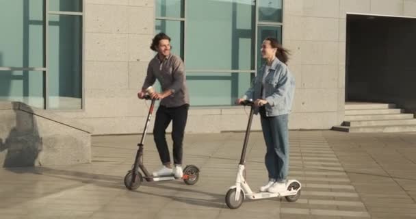 Pasangan menggunakan skuter listrik di kota — Stok Video