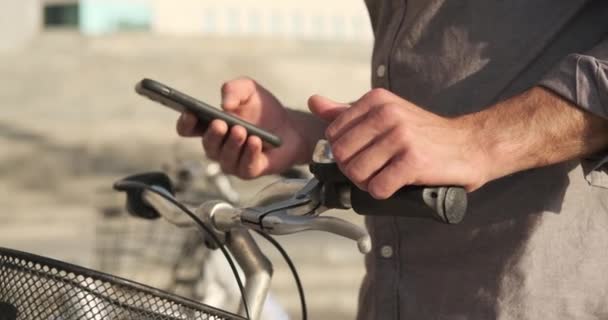 Hombre usando el teléfono móvil y a punto de montar un e scooter — Vídeos de Stock