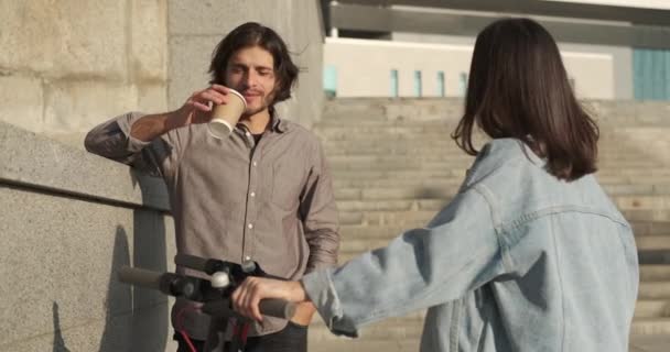 Freunde im Gespräch mit Kaffeetasse und E-Roller in der Stadt — Stockvideo
