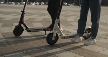 Şehir caddesinde scooter kullanan bir çift.