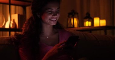 Gece geç saatlerde evde cep telefonu kullanan bir kadın.