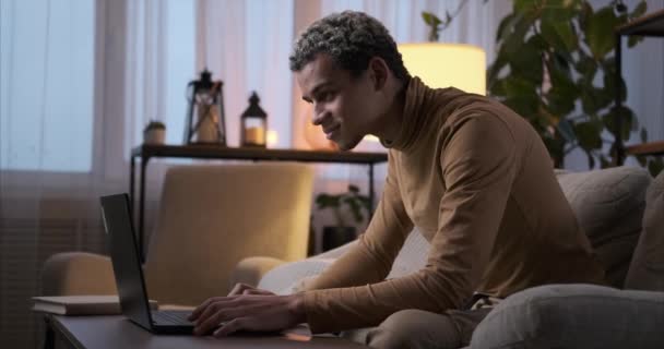 Hombre usando el ordenador portátil tarde por la noche en casa — Vídeo de stock