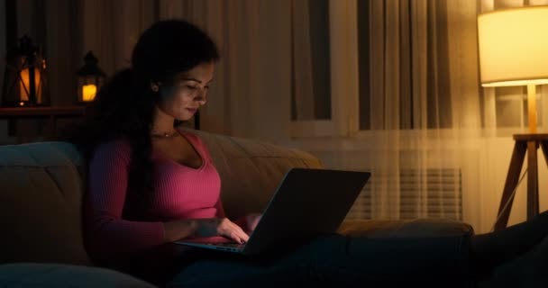 Vrouw chatten met behulp van laptop 's avonds laat thuis — Stockvideo