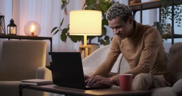 Hombre usando el ordenador portátil y beber café en casa — Vídeo de stock