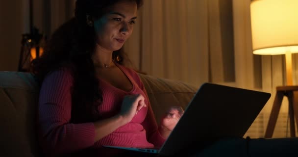 Vrouw chatten met behulp van laptop 's avonds laat thuis — Stockvideo
