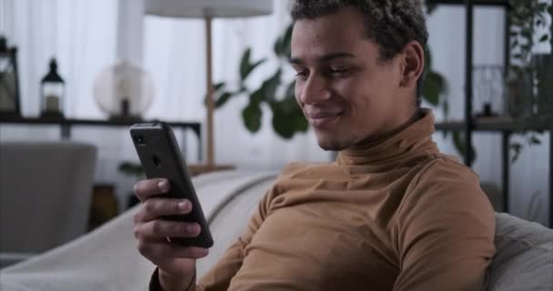 Muž baví používání mobilního telefonu doma — Stock video
