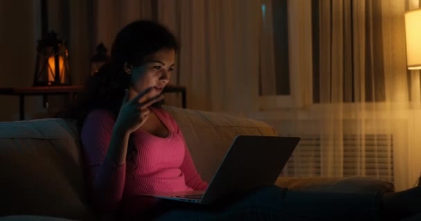Vrouw video chatten met behulp van laptop 's avonds laat thuis — Stockvideo
