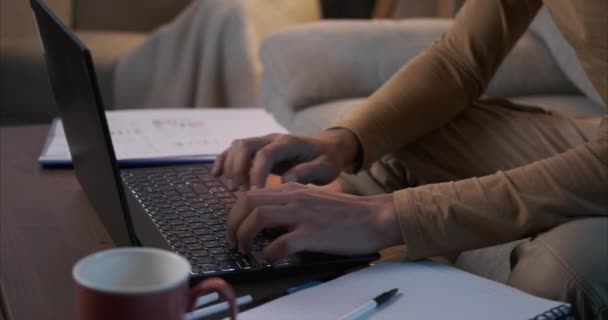 Людина використовує ноутбук і аналізує документи в домашньому офісі — стокове відео