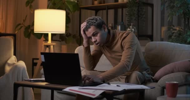 Ospalý muž pracuje na notebooku pozdě v noci doma — Stock video