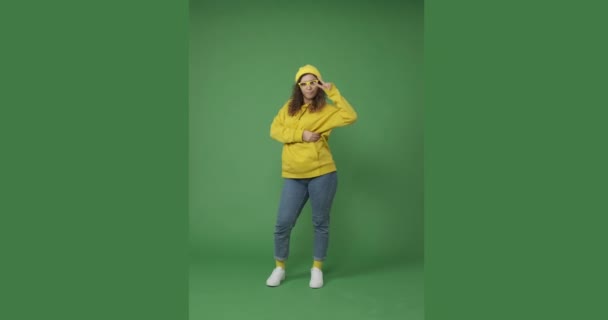 Dans eden ve yeşil arka planda poz veren kadın — Stok video