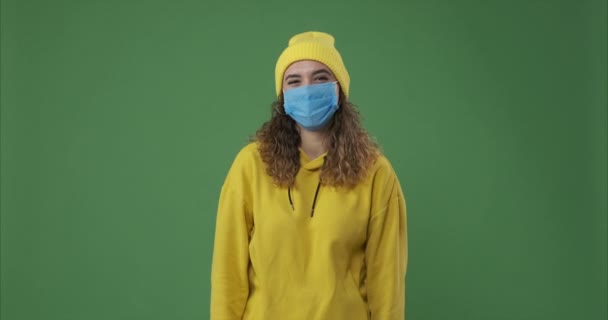 Mujer con mascarilla protectora y riendo sobre pantalla verde — Vídeos de Stock