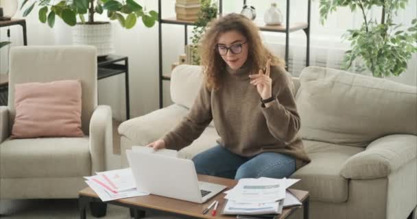 Kvinde kommer op med en god ide, mens du arbejder på laptop derhjemme – Stock-video