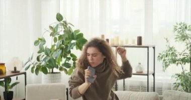 Cep telefonunu mikrofon olarak kullanan bir kadın.