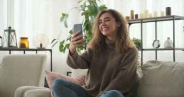 Evde cep telefonu kullanan bir kadın görüntüsü.