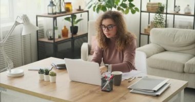 Belgeleri analiz eden ve dizüstü bilgisayarda çalışan kadın.