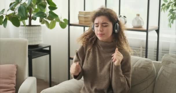 Женщина слушает музыку в наушниках и танцует — стоковое видео