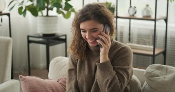 Женщина разговаривает по мобильному телефону дома — стоковое видео