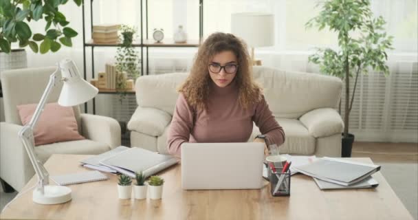 Mujer analizando documentos y trabajando en laptop — Vídeo de stock