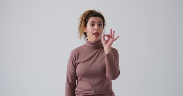 Frau gibt Daumen nach oben und ok Handzeichen über weißem Hintergrund — Stockvideo