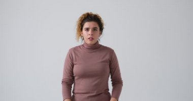 Kadın korku içinde çığlık atıyor ve beyaz arka planda rahatça iç çekiyor.