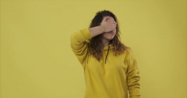 Hoş olmayan bir şeye bakarken yüzünü kapatan kadın.