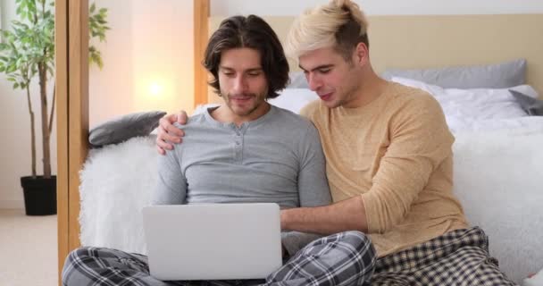 Homosexuella par använder laptop i sovrummet — Stockvideo