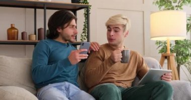 Evde dijital tablet ve cep telefonu kullanan eşcinsel çift