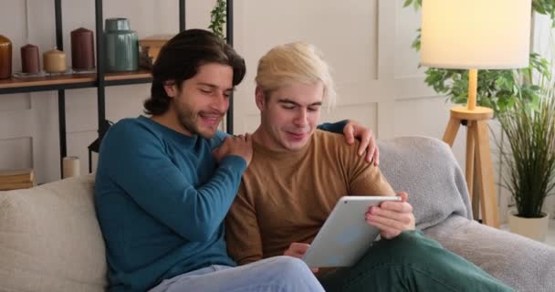 Homem compartilhando conteúdo de mídia em tablet digital com namorado em casa — Vídeo de Stock
