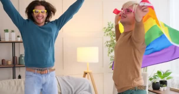 Gay coppia danza con arcobaleno LGBT bandiera a casa — Video Stock