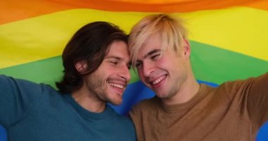 lgbt bayrağına sarılmış iki eşcinsel adam.