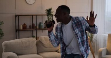 Cep telefonunu mikrofon olarak kullanan bir adam.